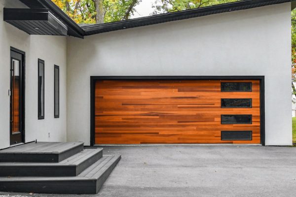 Modern home exterior with custom wood garage door and horizontal glass inserts